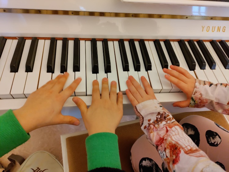 Lasten sormet pianon koskettimilla