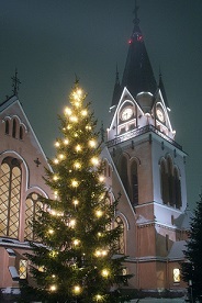 Kirkko ja kirkon edustalla valaistu joulukuusi